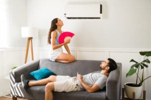 Couple in living room with air conditioner on